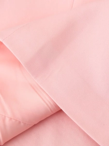 Detailed macro texture of pink blazer fabric showing high-quality weaving and stitching