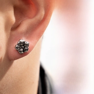 Close-up of vintage floral stainless steel stud earring featuring intricate petal texture
