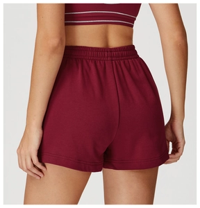 Dettaglio dei pantaloncini sportivi bordeaux a vita alta con fascia elastica e tessuto morbido