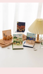 Detail view of 3D pop-up greeting cards featuring animal desert and forest scenes