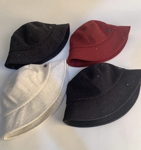 Close-up of wool fisherman hats in four colors with shimmering silver sequins and metal trim