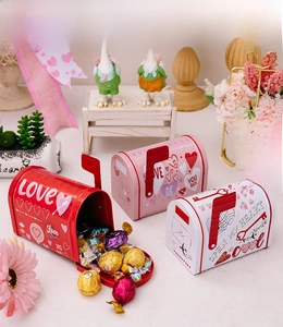Close-up of heart-themed tin mailbox gift boxes in red, pink, and white for Valentine's