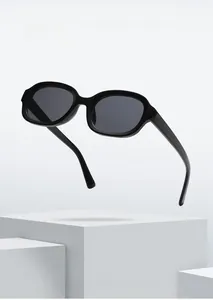 Detail of oval black candy-colored sunglasses frame on white geometric display stand