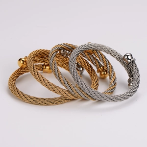 Stack of gold and silver stainless steel twisted cable open bangles with ball ends
