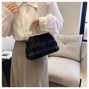 Detailed macro view of 3D lace floral patterns and luxury rhinestone clasp on black evening bag