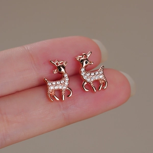 Vista macro di orecchini a lobo a forma di renna in oro rosa con zirconi sulla punta del dito