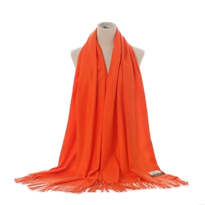 Detail view of vibrant orange cashmere-feel fringed scarf shawl for autumn winter warm wear.