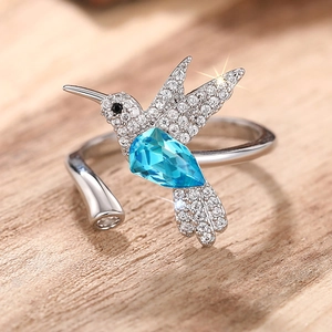 Macro detail van zilveren kolibrie ring met blauwe druppelsteen en witte zirkonen