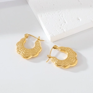 Detail of gold-plated stainless steel earrings with textured finish and snap closure