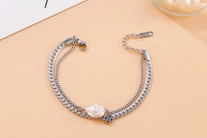 Detail of double-layer stainless steel bracelet with baroque pearl and star charm