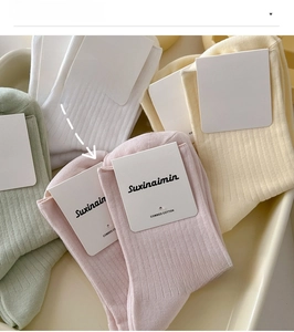 Detail of colorful combed cotton mid-calf ribbed socks in minimalist packaging