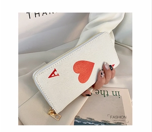 Detail of canvas long wallet with Ace of Hearts design and golden zipper closure