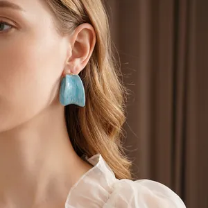 French retro sky blue marble texture irregular hoop earrings worn by a model