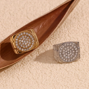 Close-up of gold and silver signet rings with micro-pave crystals on textured background