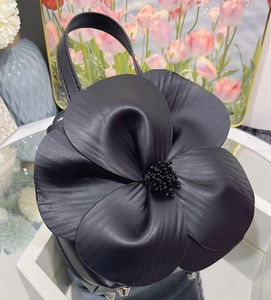 Macro shot of 3D black flower tote bag with leather texture and matte center detail