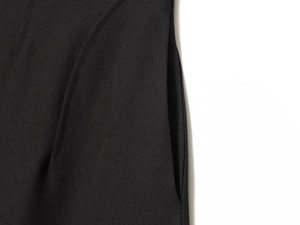 Détail rapproché de la couture de la poche latérale sur un ensemble tailleur noir