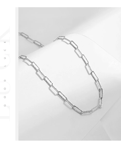 Macro detail of silver paperclip chain with unique hammered texture on white display
