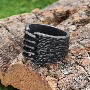 Close-up of vintage distressed stainless steel ring with rustic bark texture on wood