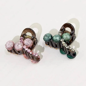 Detail of vintage style hair claw clips with green pearls and pink rhinestones set