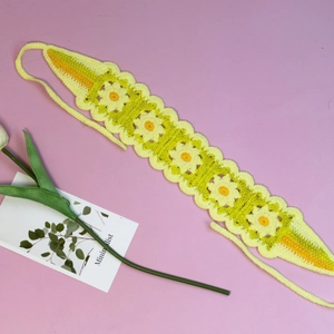 Close-up of handmade crochet headband featuring yellow and white daisy floral patterns