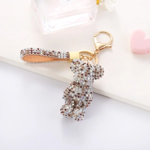 Close-up of sparkling rhinestone teddy bear keychain with brown leather strap detail
