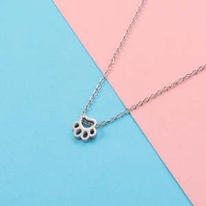 Detailed close-up of a silver stainless steel hollow cat paw pendant on a thin link chain