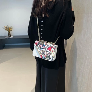 White leather crossbody bag with colorful graffiti print and gold chain strap for women
