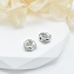 Silver twisted knot stud earrings featuring micro-pave clear cubic zirconia stones