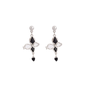 Détail de boucles d'oreilles cyberpunk en métal argenté avec gemmes noires et strass brillants