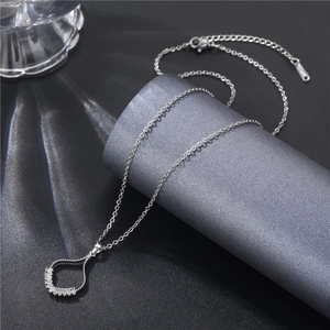 Macro shot of silver skirt necklace pendant with zircon stones on a dark display stand