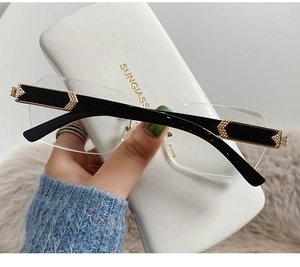 Detail of frameless sunglasses with gold metal trim and branded white case