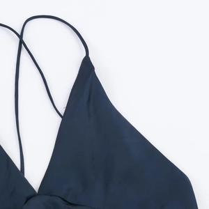 Gros plan sur une robe en satin bleu foncé avec des fines bretelles et un tissu lisse