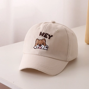 Dettaglio del ricamo a cane e scritta HEY sul berretto da baseball beige per bambini