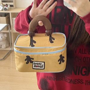 Macro detail of Lucky House makeup bag with yellow fabric and brown handle contrast