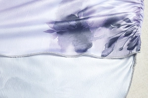 Détail de l'imprimé floral violet sur satin soyeux avec couture fine à ourlet roulé