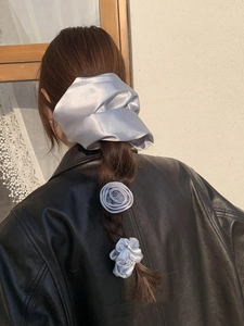 Detailed back view of a silver grey satin hair scrunchie set with rose hair clip on hair