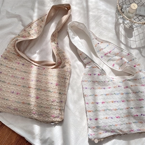 Close-up of woven crochet tote bag with colorful thread detail and wavy lace texture
