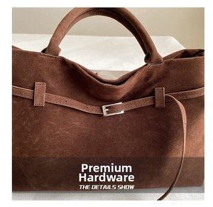 Close-up of dark brown faux suede tote featuring premium silver buckle and strap detail