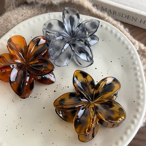 French vintage leopard print floral hair claws in amber and grey on a ceramic plate