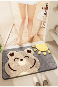 Close-up of grey cartoon bear bath mat with high-absorbent plush texture in use