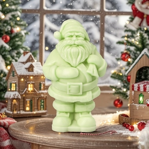 Green Santa Claus aromatherapy candle on a snowy table with a festive Christmas tree