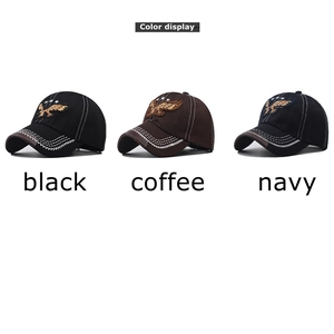 Dettaglio del ricamo dell'aquila su cappellini da baseball nero, caffè e blu navy