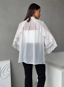 Detail view of white chiffon blouse back with layered ruffle bell sleeves on a female model