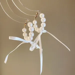 Elegant French pearl hoop earrings with white ribbon bows for a sweet look