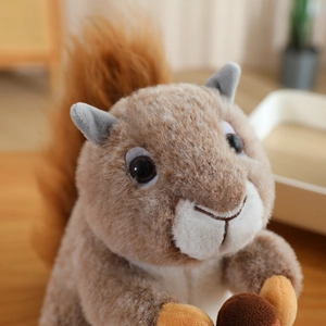 Close-up of a plush squirrel toy holding an acorn with fluffy tail and soft texture
