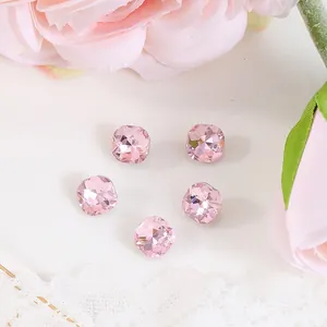 Macro shot of 8x8mm pink square faceted rhinestones for nail art on lace background