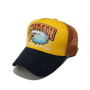 Détail de la broderie aigle et maille sur casquette trucker jaune et bleue d'été