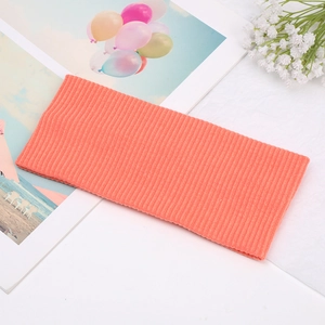 Detailed macro view of coral orange ribbed knit texture on soft elastic headband