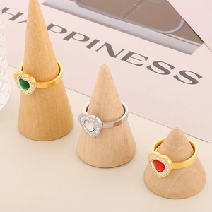 Detailed view of heart-shaped gemstone rings with zircon halo on wooden display stands