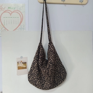 Detail of canvas leopard print tote bag with long strap and spacious interior design